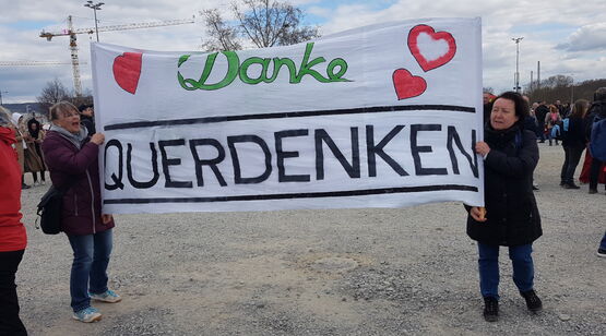 Zwei Damen halten ein großes Leinentuch mit Dankesgruß an die Veranstaltung