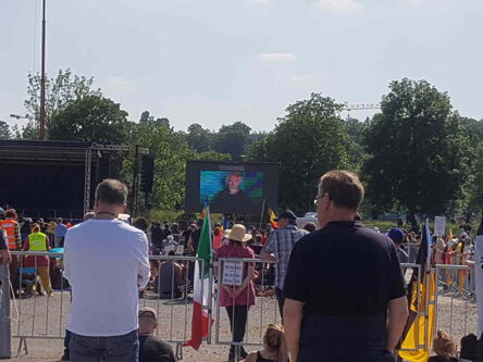 Demonstranten vor der Bühne. Frau mit Hut und Schild