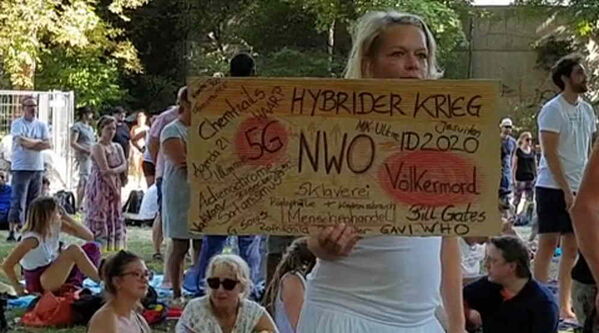 Frau in weiß gekleidet mit vielschichtigem Text auf Karton