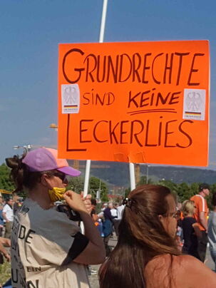 Zwei junge Damen ein Schild in knallorange
