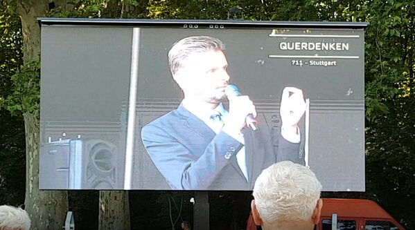 Florian Schröder auf der Leinwand bei Querdenken-Demo