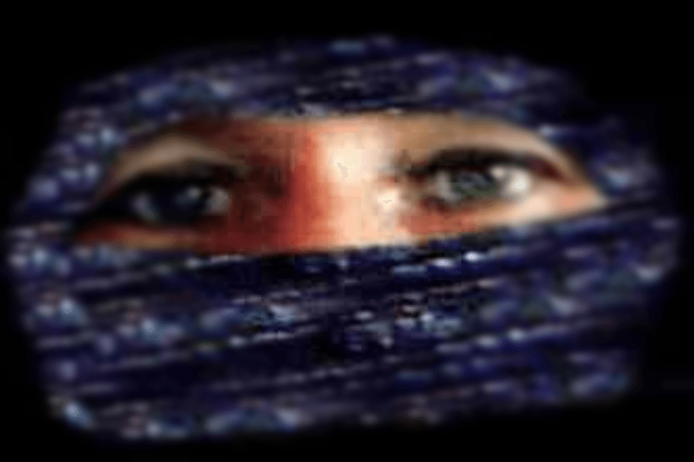 Eine Person, bei der nur die Augen zu sehen sind -- mit schwarz-silbrigem Tuch um Mund, Nase und Haare