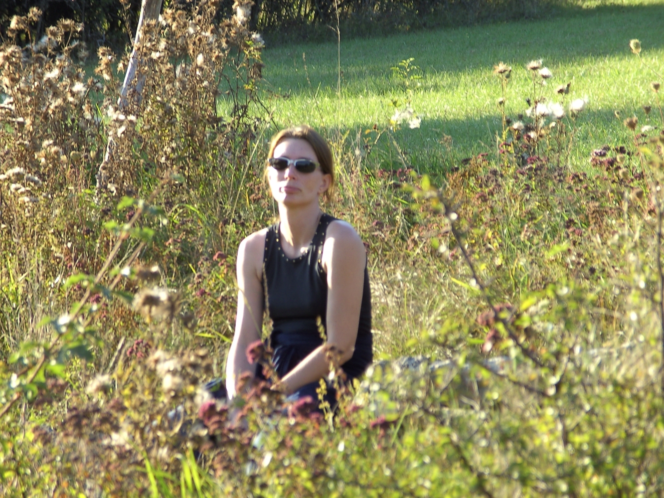 Peggy mit Sonnenbrille draußen zwischen den Diesteln